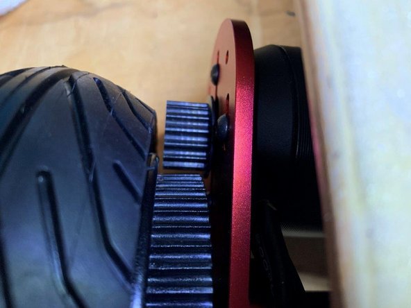 Remove the piece of paper, and you should have a small gap between the motor pulley and tire hub