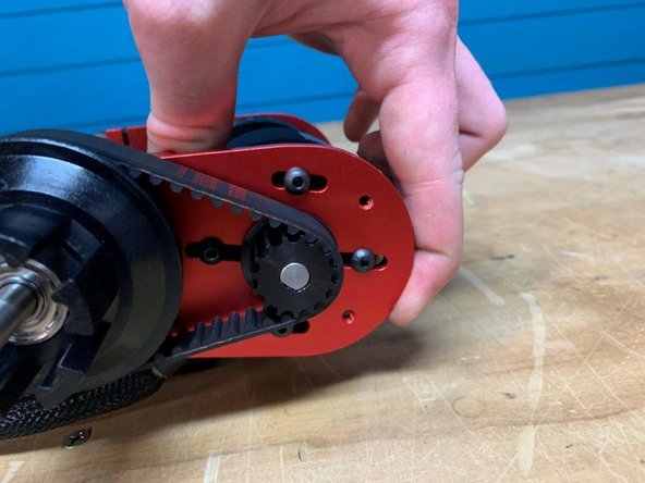 Slide the motor outwards from the truck to put tension on the belt