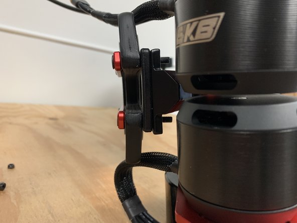 Add the drivetrain with the motors facing the rear to the bolts (do not add the locknuts yet)