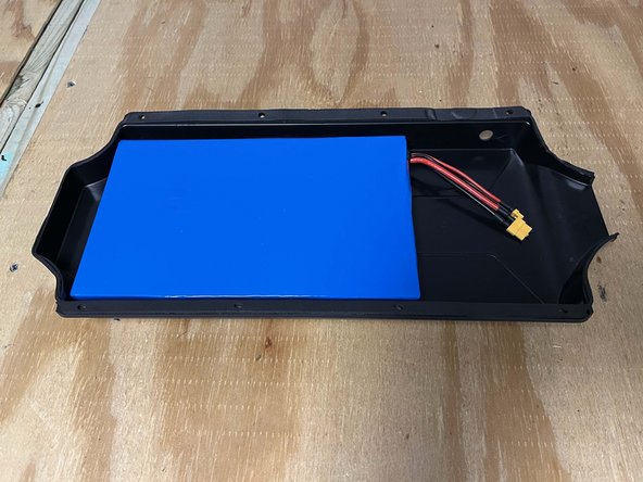 Firmly press the battery into the enclosure as shown to secure it in place