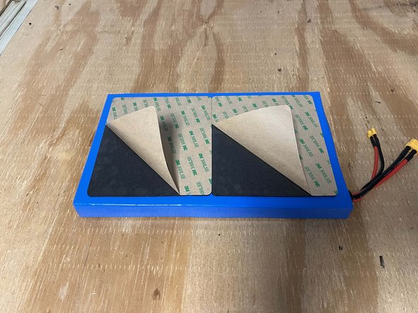 Peel the paper backing off of the batteries adhesive pads