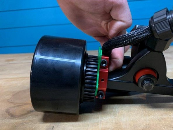 Place the motor mount spacer (green, blue, or black) in between the motor mount and wheel pulley. The wheel should not be able to move laterally on the truck