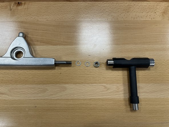 Remove the locknut and 1 silver washer from the Front Hanger in section 2 using the T-Tool. One silver washer should remain on the front truck (this photo shows both of them removed)