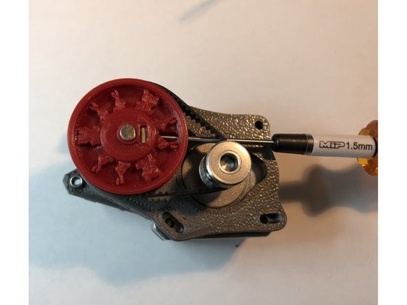 Slide large pulley down shaft until it almost contacts spacer.