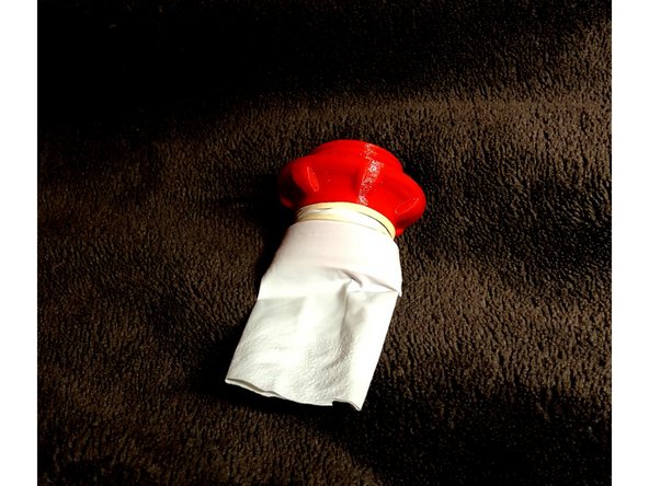 Cut one of the longest fingers from glove. Stretch its open end over flutter valve fitting. Notice that the glove finger has a natural flatness. Also, the flutter valve penetrator has an elliptical end. Align flatness of glove finger with long axis of valve ellipse.