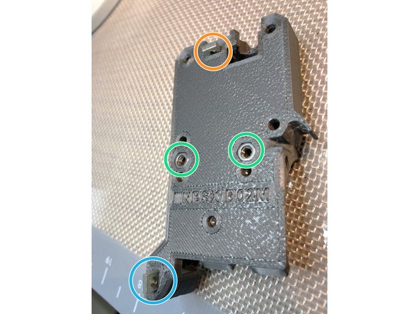 Insert hot end cover mounting M3 nuts. These nuts must be fully seated and not protrude beyond rear surface of extruder body.