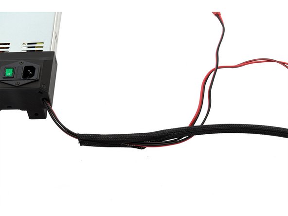 Schieben Sie nun die Netzteilkabel durch den Techflex-Schlauch. Schieben Sie den Schlauch etwa ein 1cm in das Netzteil hinein.