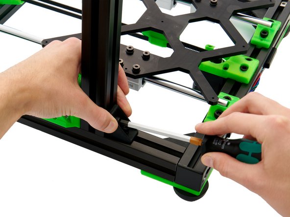 Positionieren Sie die 2x Nutensteine im y-Profil unter der Öffnung im z-Motorhalter und unter der Bohrung im Eckwinkel.