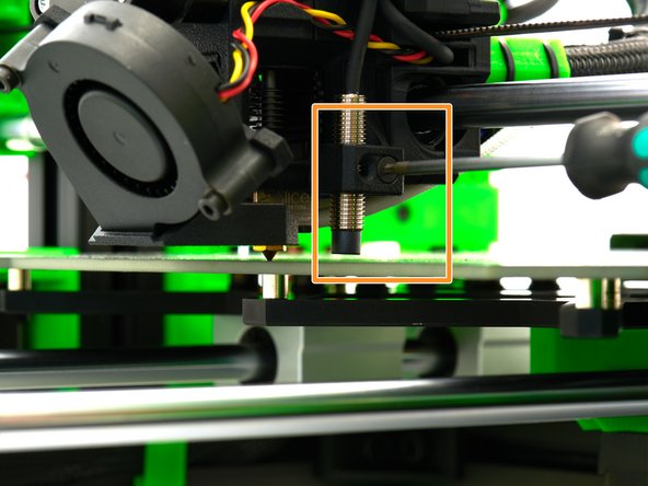 Turn the two spindles of the z-stepper motors simultaneously and evenly downward until the nozzle touches the bed.
