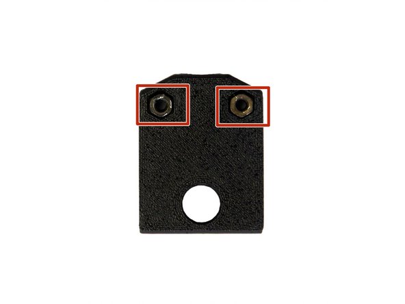 Setzen Sie 2x M3 Sechskantmuttern in die dafür vorgesehenen Löcher in der unteren Heizbettabdeckung.