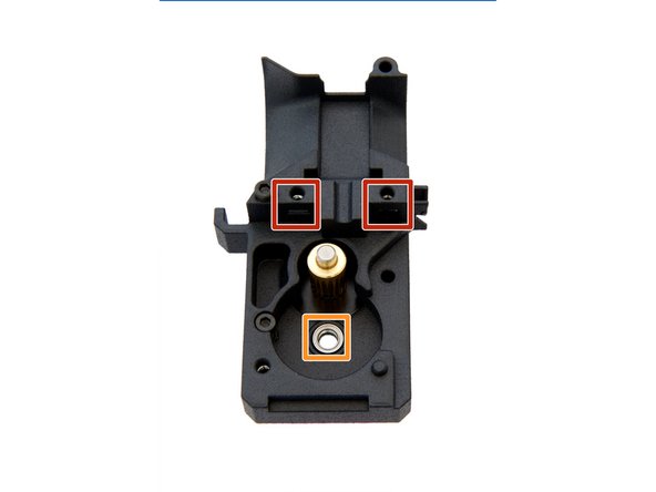 Stecken Sie eine M3 Vierkantmutter  in das Loch, in der Mitte der Extruder Rückseite. Kontrollieren Sie, dass die Quadratmutter im linken Schlitz vorhanden ist.