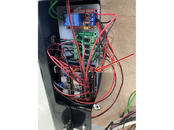 Remove the CNC shield from the Arduino board. The CNC Shield is the red board in the bottom of the picture with a lot of wires connected to it. It can be removed by carefully pulling it towards you.