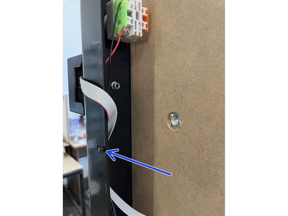 Tie the ribbon cable from the VFD display and the Emergency Stop cable to the front plate with a 2.5mm cable tie in the hole provided as shown in the picture.