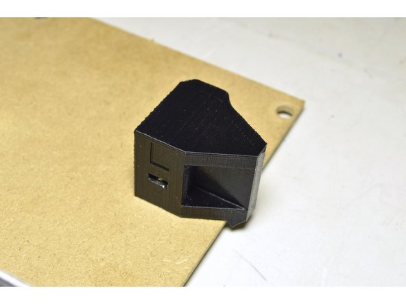 The lip of the printed part will stick over the edge of the board to keep it from rotating