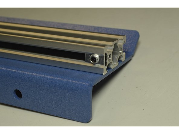 Pull the belt with the one hand, while fastening the grub screw with the other hand.  Else, ask someone else to pull the belt while you tighten the Grub screw.