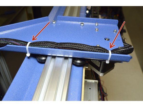 Use the Cable Ties (3 Pcs) and mount the X-Axis Cables to the Left Y-Carriage Plate as shown.  There are slots for all 3 cable ties in the blue plates
