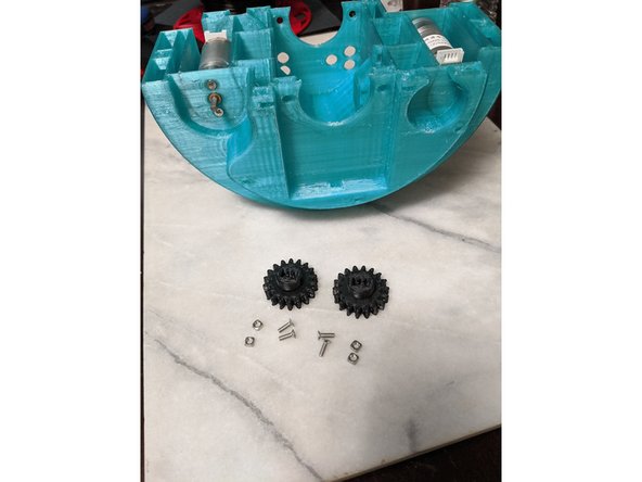 For the next two steps we will use the MainFrame assembly with drive motors attached, 4x M3 x 10mm long screws, and 4 M3 square nuts, and PololuGearA and PololuGearB.