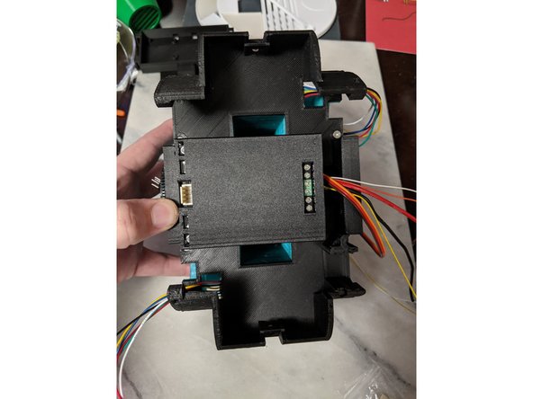 Place the TopFrame on the Frame, bringing the drive motor wires through the holes in the top frame, and the main bar wires and center servo wires will be in the notch on the side with the motor drivers screw terminals.  This can be seen in Pic 2.