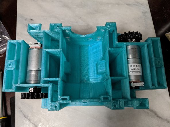 Lining up the hole for the screw on the gear with the flat of the motor, attach the gear to the motor with the M3 x 10mm long screw making sure to screw onto the flat of the motor shaft.