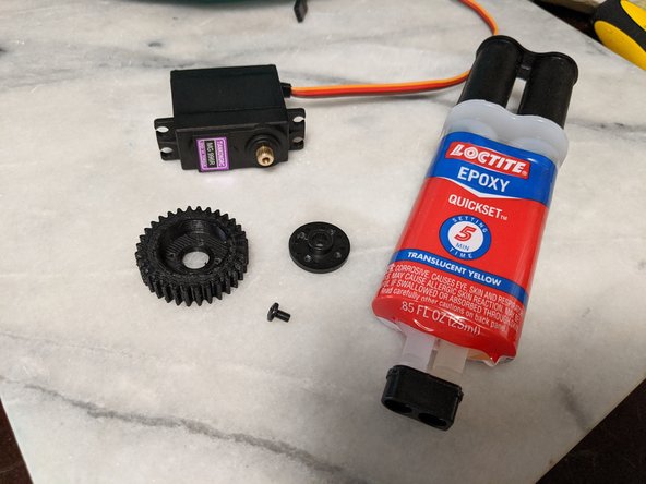 This step will use the MG996R Servo, MainServoGear printed part, the center screw for the servo, the round servo attachment, and 2 part epoxy.