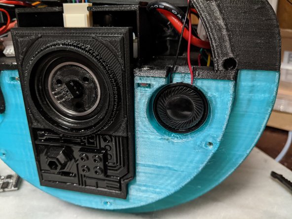 As seen in Pic 2 and Pic 3, press the speakers into the frame with the wires coming up through the notch in the frame.  Make sure the speakers are pressed against the frame well and perhaps use something to hold them in place while the epoxy dries.
