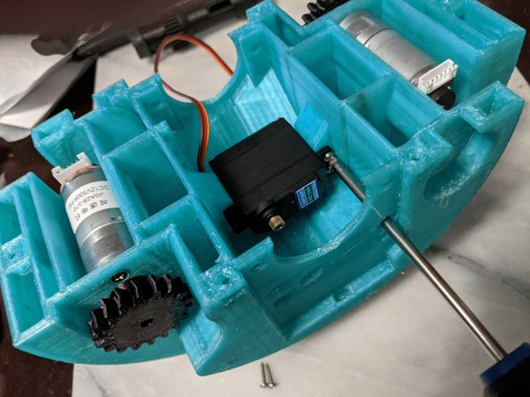 Insert the servo into the center of the MainFrame lining up the drive sprocket with the hole on the side of the MainFrame.