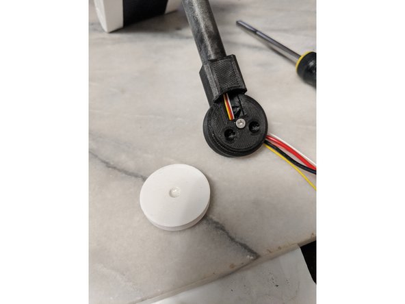 Mix up a small amount of 2 part epoxy and put a small drop into the center of the MainBarCap.   Do not put too much epoxy in this print because we do not want any leaking out and locking everything into place.  This is only to attach the cap to the screw.