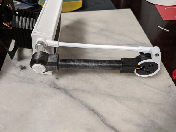 The NodArmLever goes over the MainBarHolderA print that is attached to the bottom of the HeadBar.