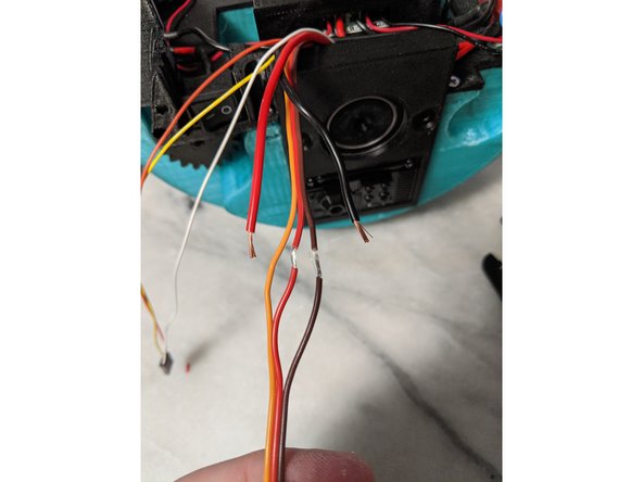 Here we will attach the power wires that go to the head servos to the servo wires that are attached to the servo in the center of the frame.