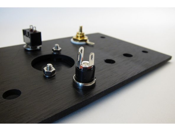 The solder lugs of the PSU barrel connector are all different lengths. Attach so the longest one is up.