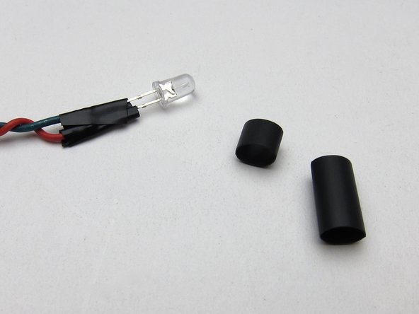 Your kit includes heatshrink that is pliable when warm and should nicely seat the LED in the hole in the front panel.
