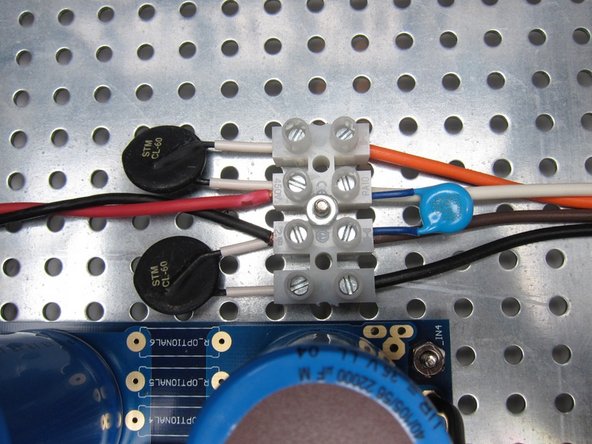 Terminal block. 120VAC wiring shown. AC from switch in from left (Red Black) CL-60's, the blue disc is the X1/Y1 rated capacitor, and transformer primaries are out the right.