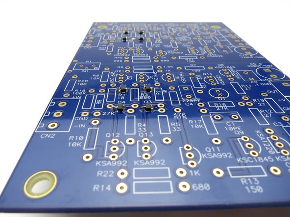 Tape the transistor in the middle of the tape, feet down, and use the rest of the tape to align it on the pads.