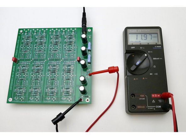 Connect power and connect your DMM as shown (the black is on ground, which happens to be the left leg of the LED, but anywhere on the PCB marked ground will be fine) and the red is at the V+ near the power jack. This should read the voltage of the PSU, which is 24VDC plus or minus a little.