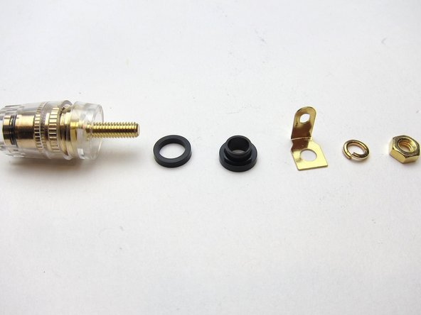 It doesn't matter if the shoulder comes first or the other plastic washer, as long as things sit squarely and the shoulder washer is inserted through the chassis so the threaded portion doesn't touch the back panel itself.