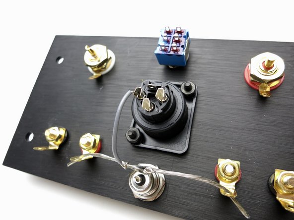 Photo 1 - Bare ground buss wire from both speaker reds to barrel ground tab.      Ground buss to XLR pin 1 (grey wire)