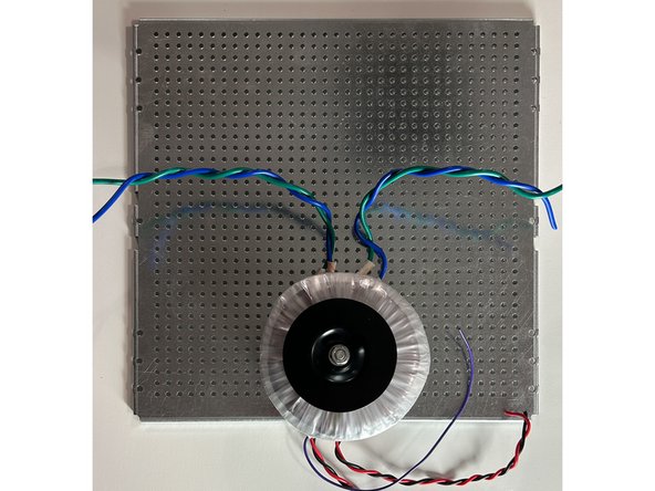 Find and mark a mounting hole that keeps the transformer centered (roughly centered is fine) left to right and close to the front of the chassis.