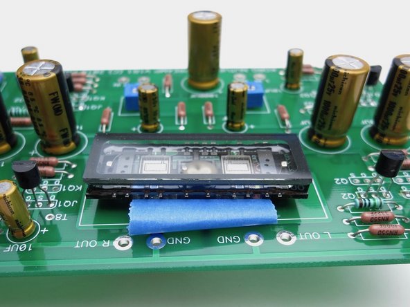Photo 1 - NuTube is next. Make a loop of tape under the NuTube to make some room above the PCB, you don't want it to touch. Solder the pins