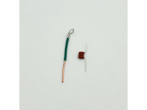 Cut approximately 3&quot;(8cm) of the green wire.  Install a ring connector to one end using the same process as the mains earth connection.  Strip a little over an inch of the insulation from the remaining end of the green wire. Bend the legs of the 0.1uF film cap as shown in photo 1.