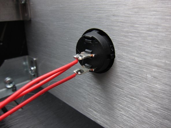 The front power switch is mounted to the panel from the front with the metal terminals in the center and down position.