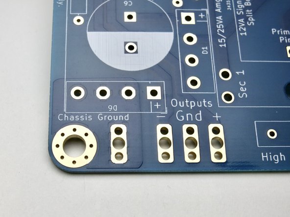 Photo 3 shows the Chassis Ground connection points and DC output where the umbilical cable will connect.  Chassis ground is connected to the audio ground by D6 ground breaker diode bridge.  Chassis needs connected to the Chassis Ground  on the PCB either through the screw or the solder pad next to the screw.
