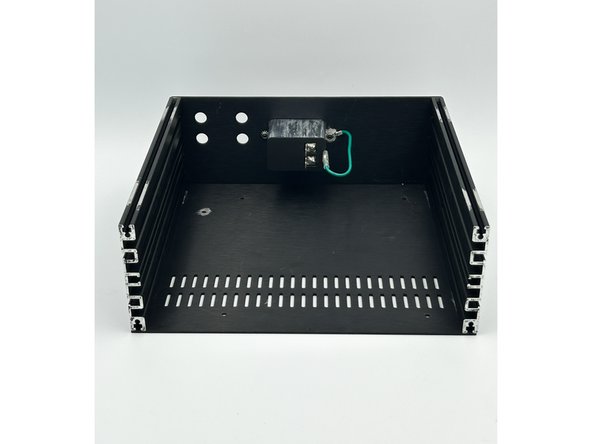 Most people like to toggle the switch 'Up' to turn the unit on.  Make sure your orientation is the way you like it.  Slide the PEM through the back panel from the exterior.  Using a black 10mm flat head screw and a Keps nut, loosely secure the PEM to the back panel on the side furthest away from the mains earth tab on the PEM.