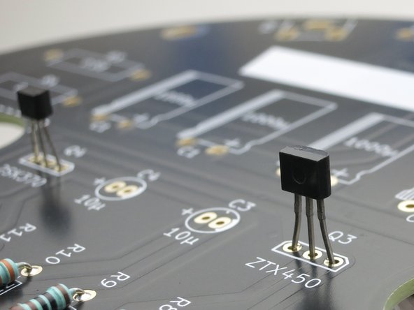 The slightly longer/bigger face of the transistor is called the flat, align it with the slightly longer side of the outline drawn on the PCB.
