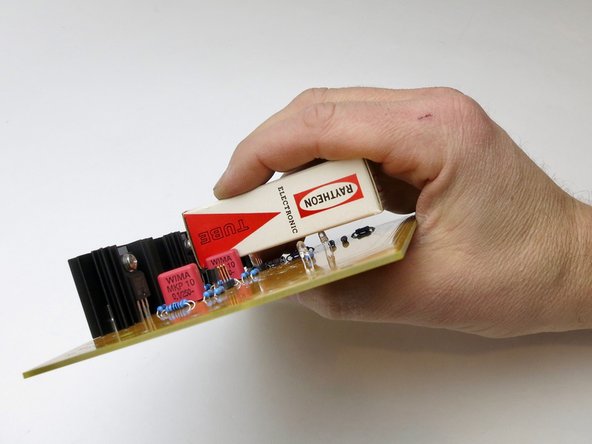 Hold the pins and PCB together as shown and flip the board over