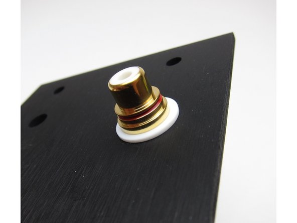 Second image: Again, viewing from the inside, the shoulder washer sits in the hole and keeps the metal of the RCA from touching the chassis