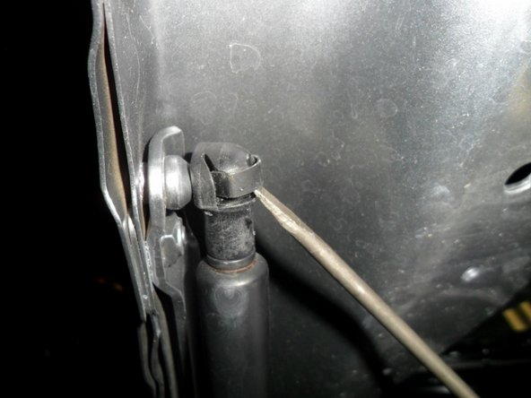 Using a small flat head screw driver , pry open metal clips on the top and bottom of strut