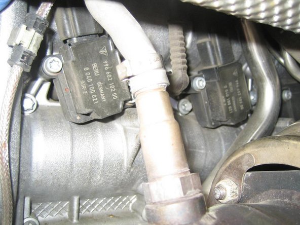 The coil packs should be visible now. Push the rubber boots up to allow the clip to be undone, then you can unbolt the coilpack and remove it. The rear 2 spark plugs can be removed now with long extensions. A wobble extension on the spark plug socket is recommended.