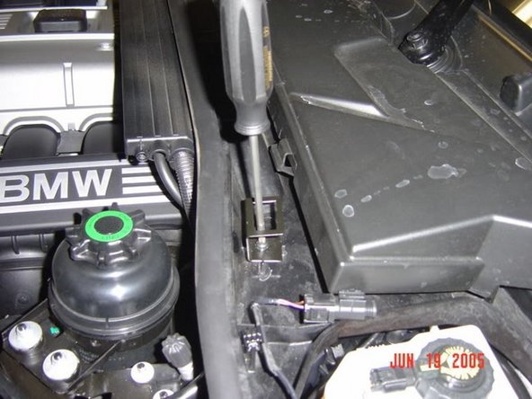 Next, mount the hood switch bracket. There is only one correct orientation of this bracket. The notch in the bracket goes toward the middle of the car and aft. Secure this with the provided screw.