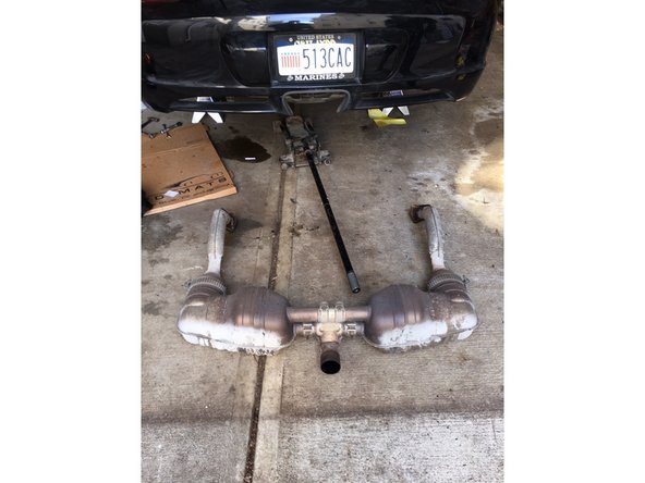 Carefully lift exhaust off exhaust studs and suspension