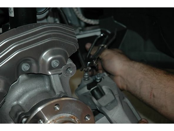 With a 14mm open end wrench unloose the brake line from the caliper.